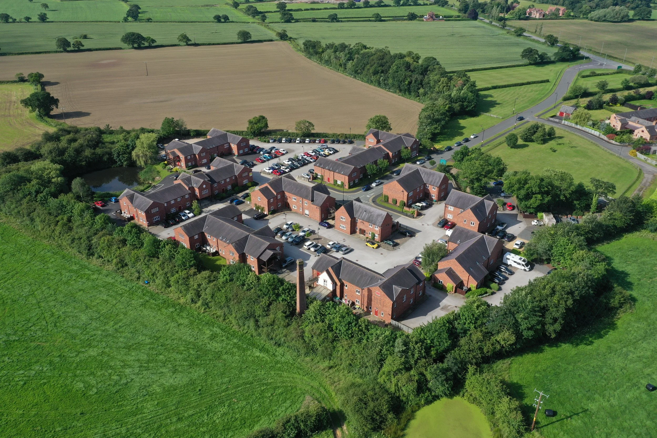 Vista aérea de un conjunto residencial rodeado de campos / Aerial view of a residential development surrounded by fields.