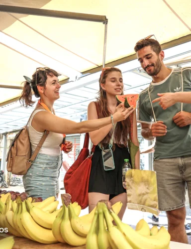 Guía explica productos del mercado durante un tour gastronómico de Athens Walking Tours