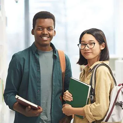 Dos estudiantes adultos con libros en una imagen institucional de BCCC