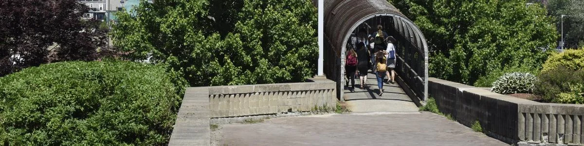 Estudiantes cruzan un puente peatonal hacia el campus de Bunker Hill Community College en Chelsea