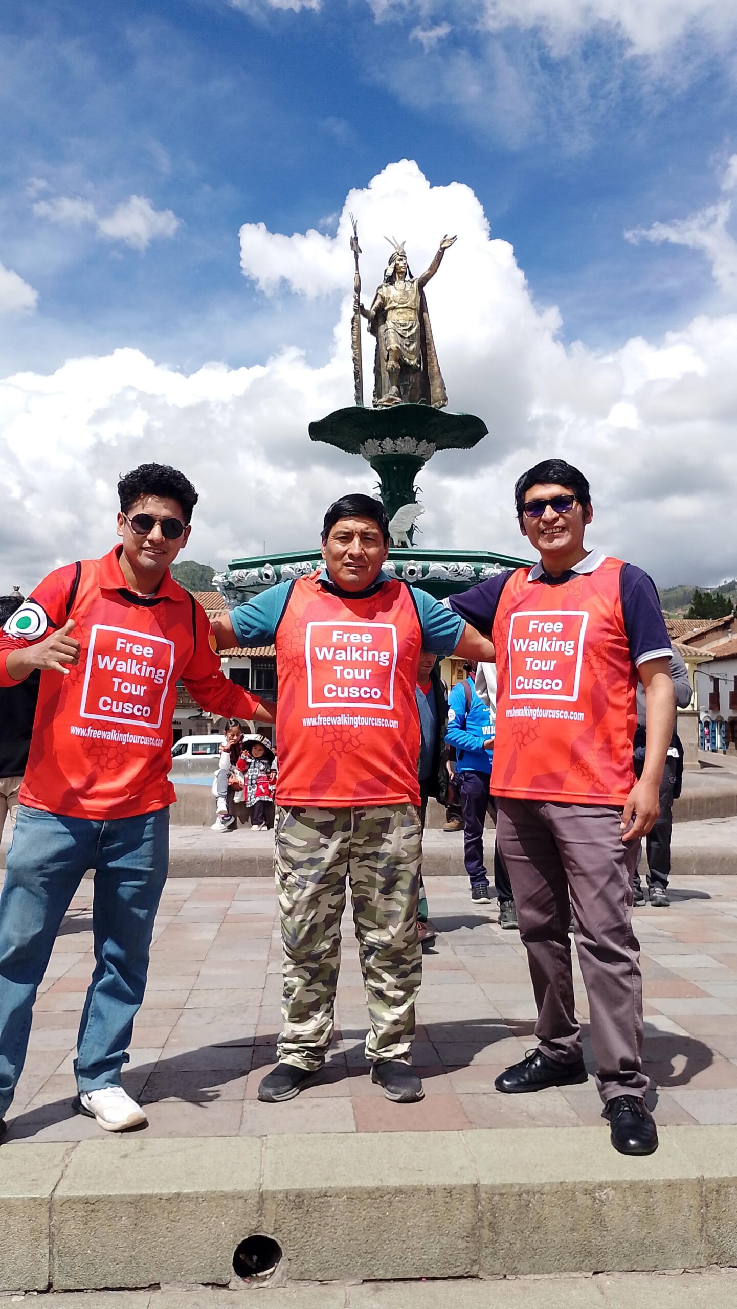 Guías de Free Walking Tour Cusco posan en el punto de encuentro de Plaza de Armas