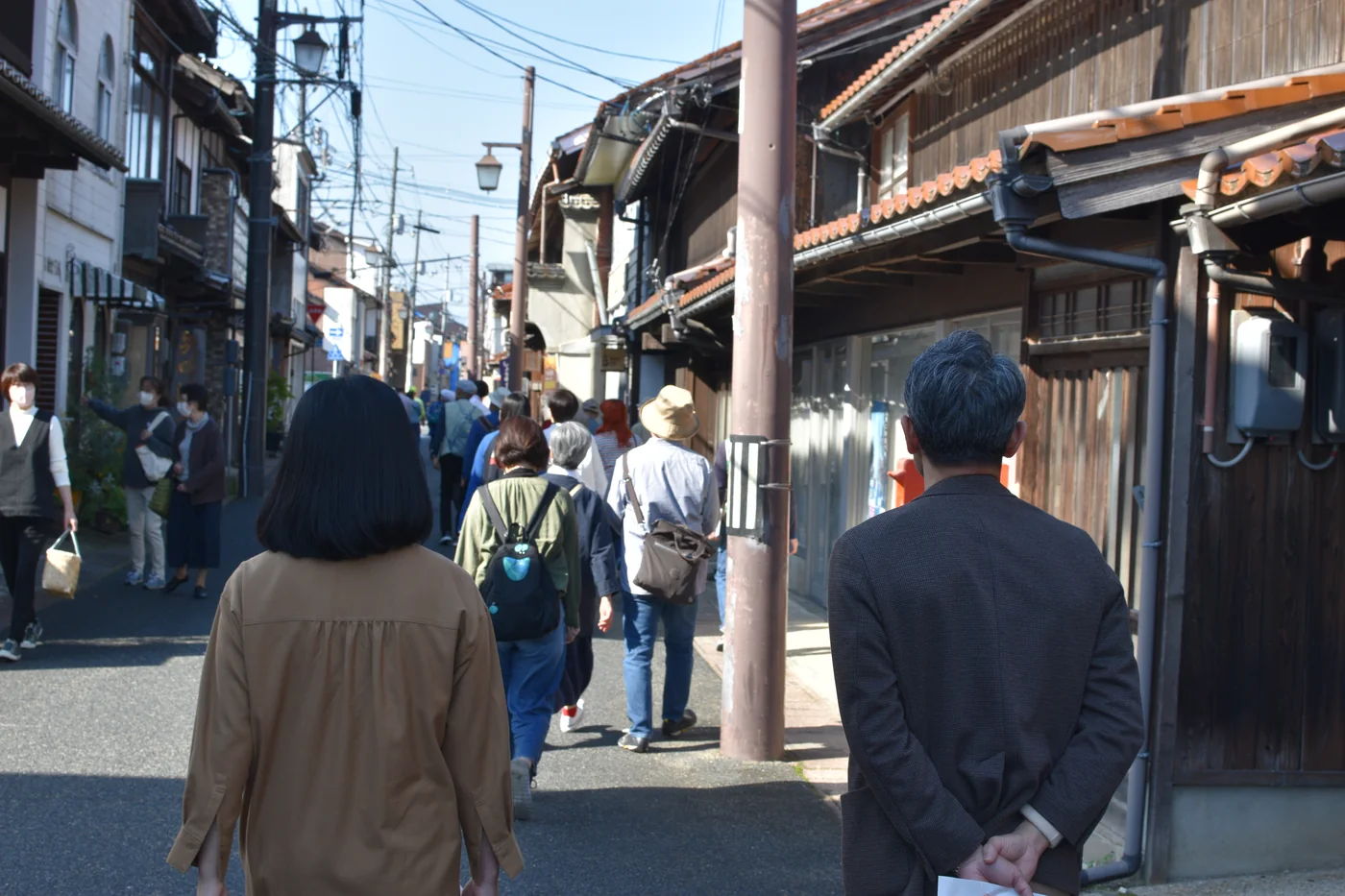 Visitantes recorren a pie una calle histórica de Kurayoshi durante una visita guiada.