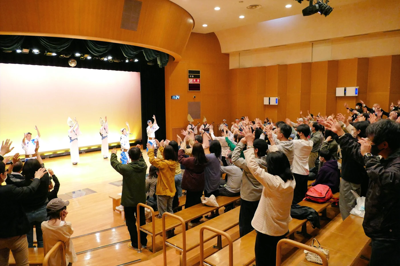 El público aprende los pasos de Awa Odori junto a bailarines en el escenario del Awa Odori Kaikan.
