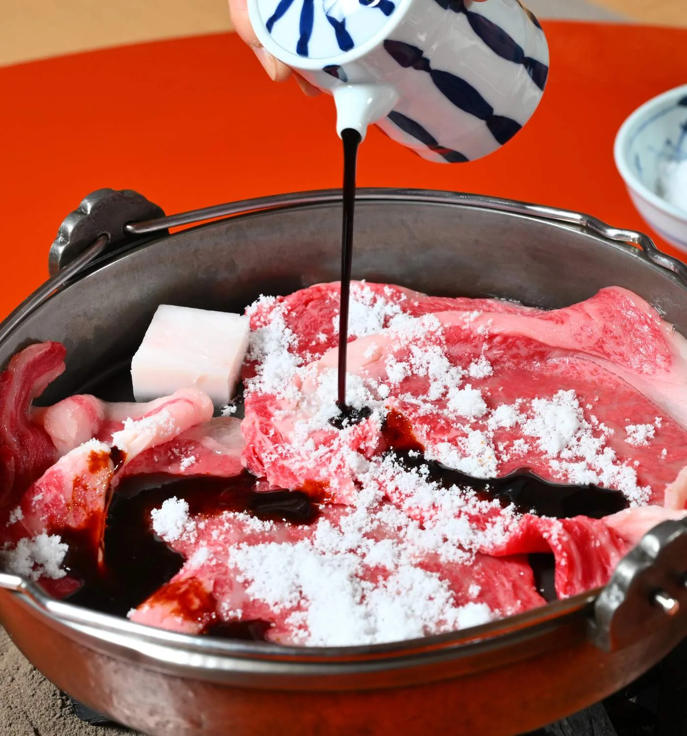 Fotografía de la preparación de sukiyaki en Wadakin, publicada en su sitio oficial.