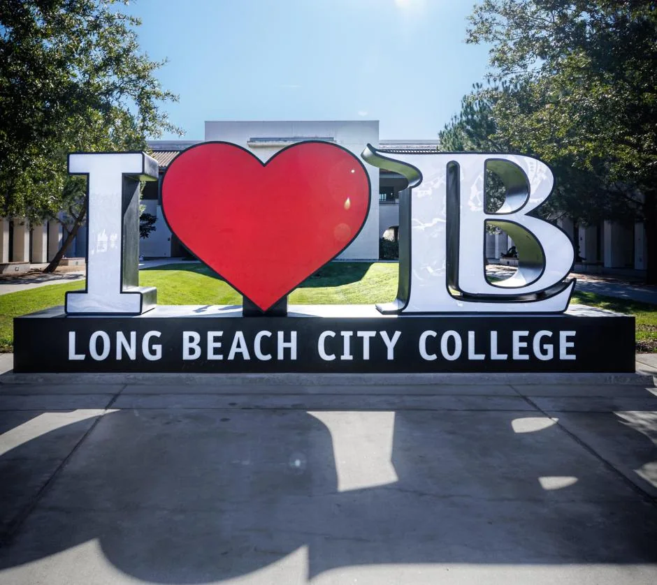 Letrero I love LB con el nombre de Long Beach City College frente a un edificio del Liberal Arts Campus