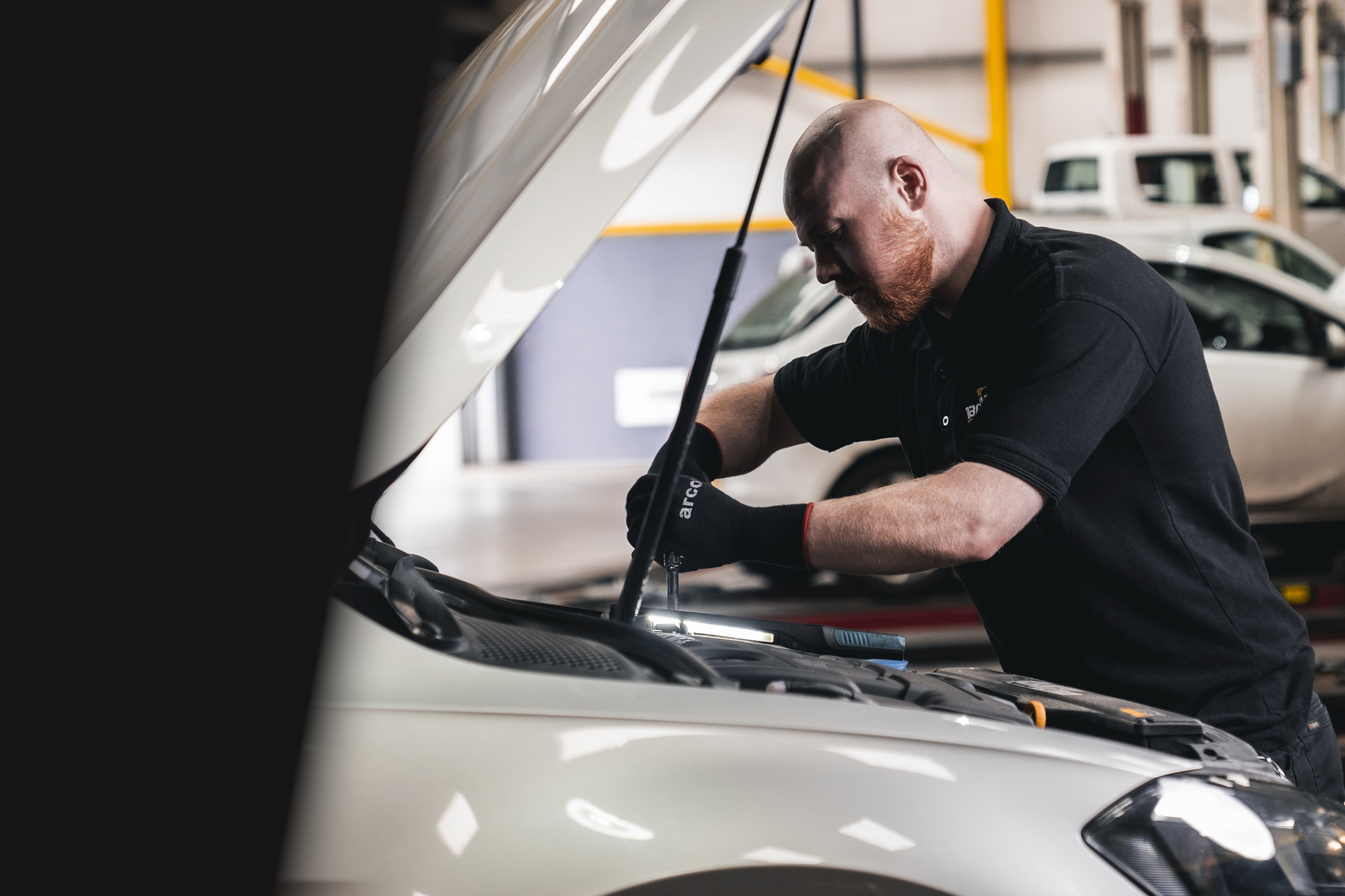 Mechanic inspecting a vehicle with its hood open