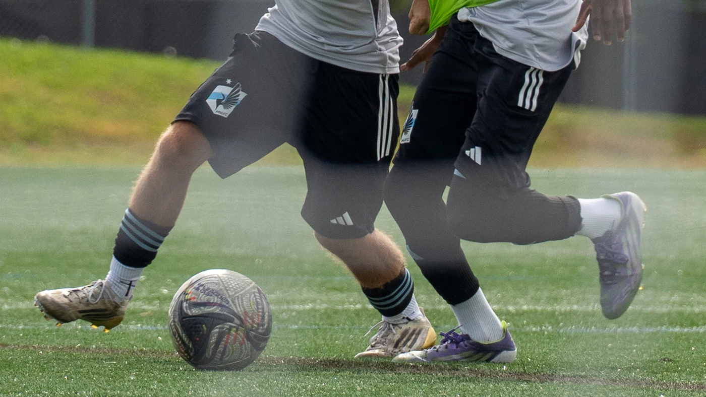 Jugadores juveniles entrenan en una cancha de fútbol.