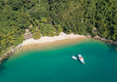 Foto de lancha y paisaje costero en el sitio de Paraty Experience