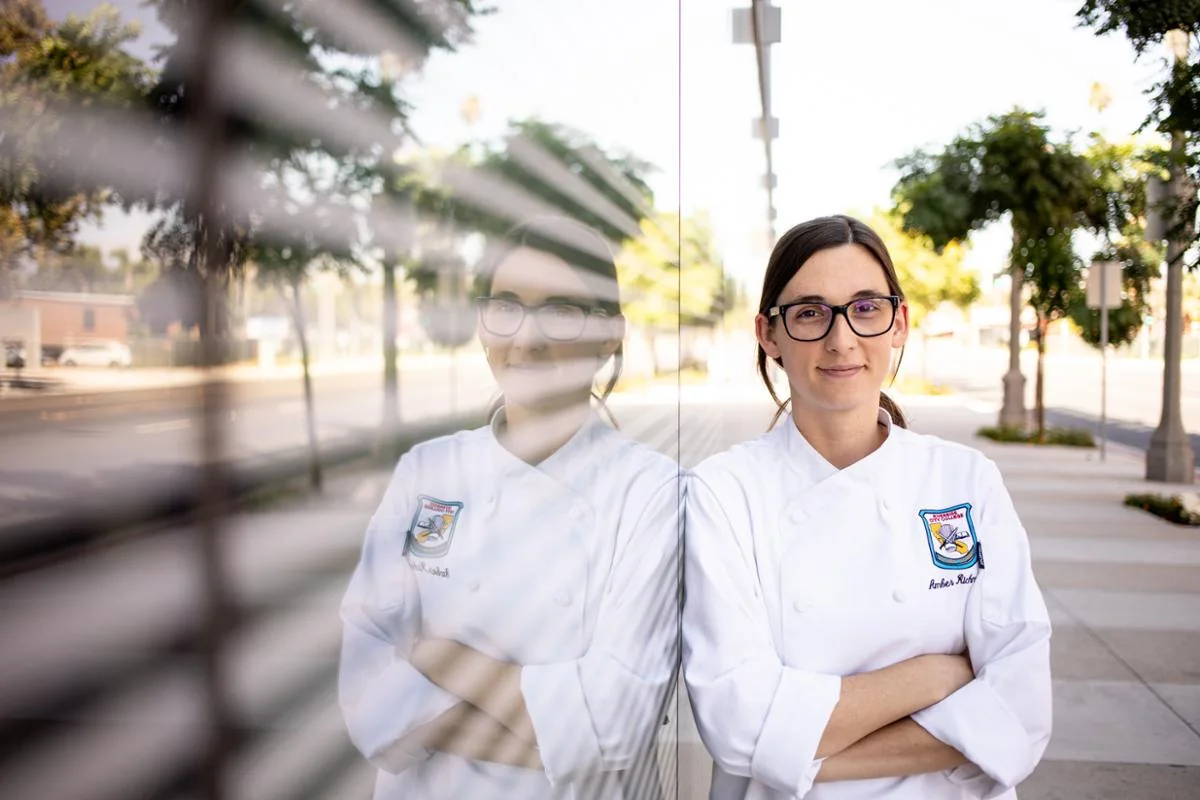 Estudiante de Culinary Arts Academy con uniforme profesional en el exterior de la sede.