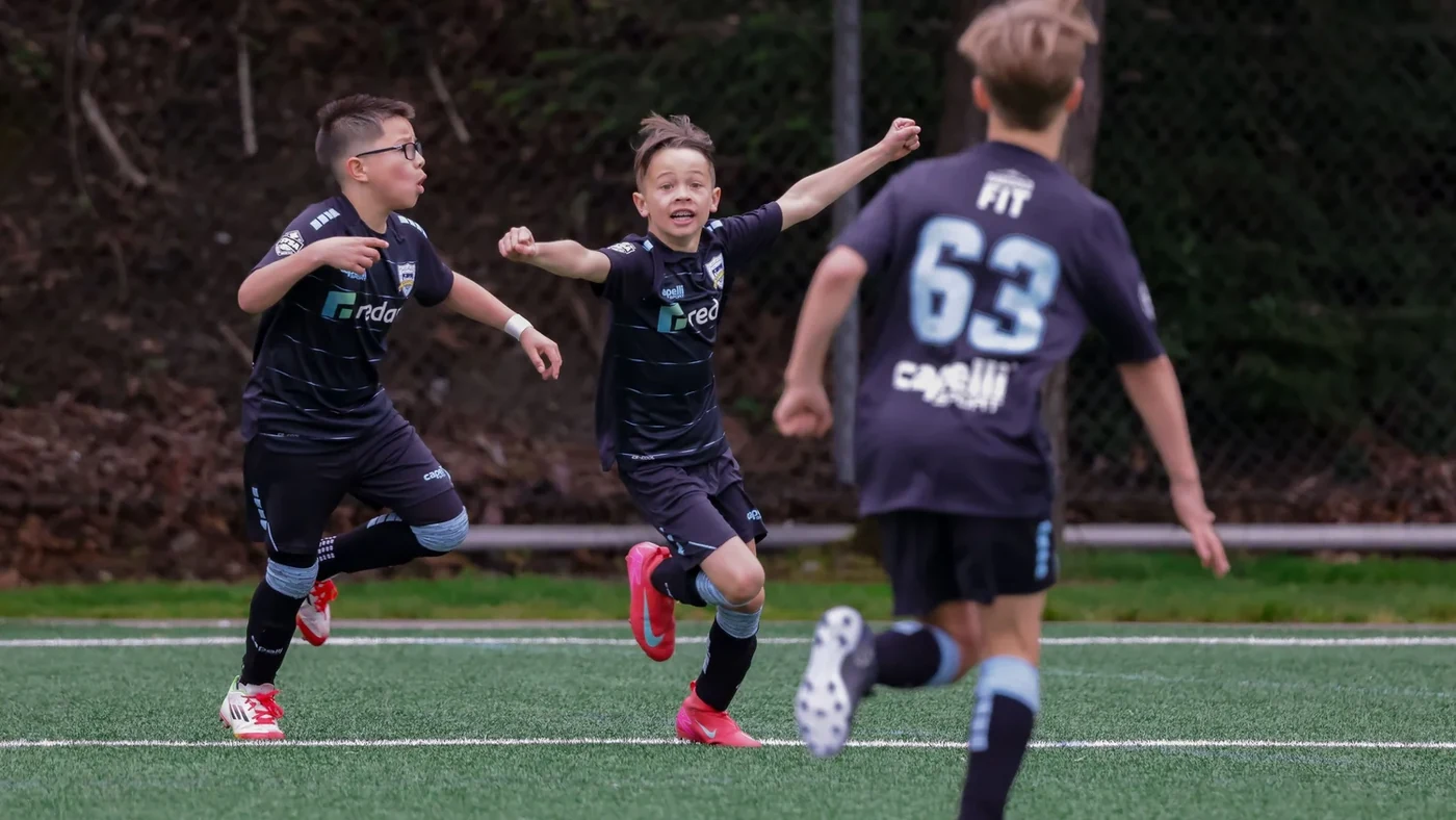 Jugadores juveniles de Seattle United posan juntos en un campo.