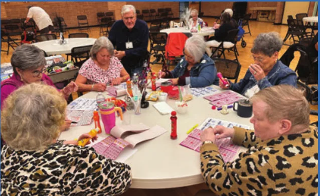 Personas mayores participan en un juego de bingo en el centro Downtown de Aster Aging.