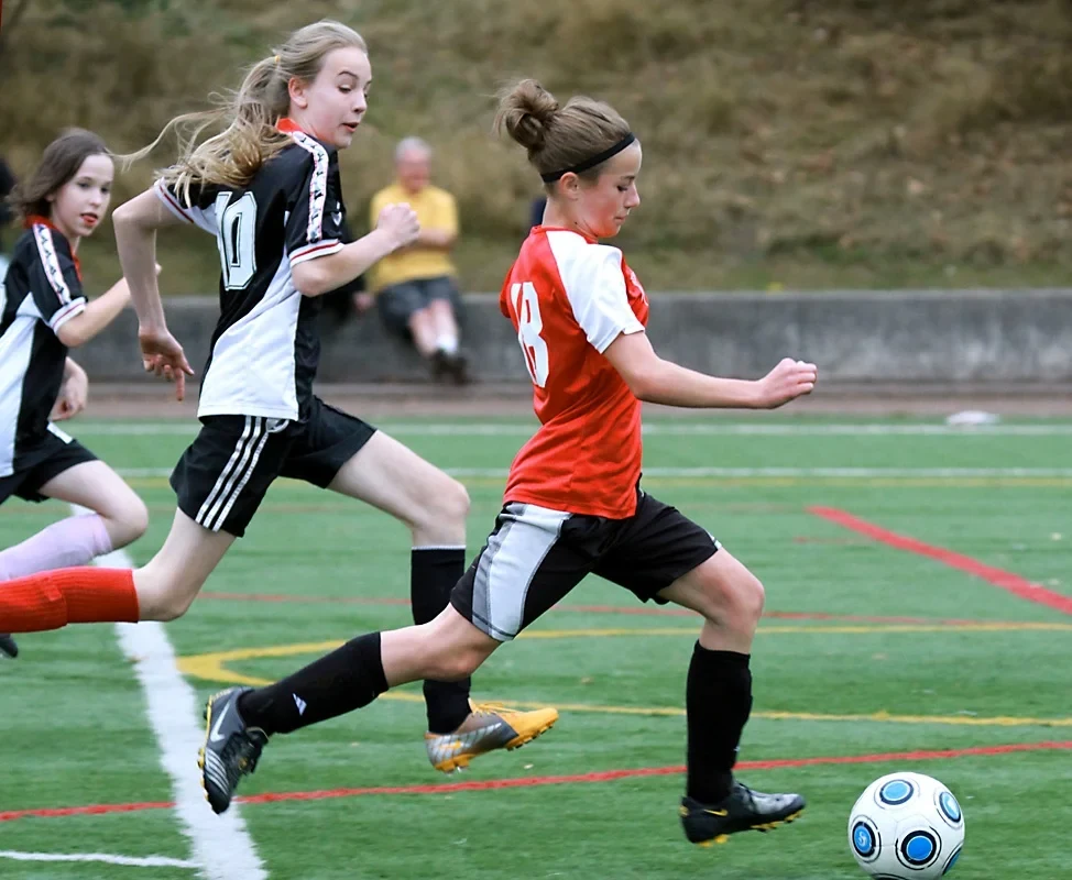 Jugadoras juveniles disputan un balón en un partido local de Seattle.