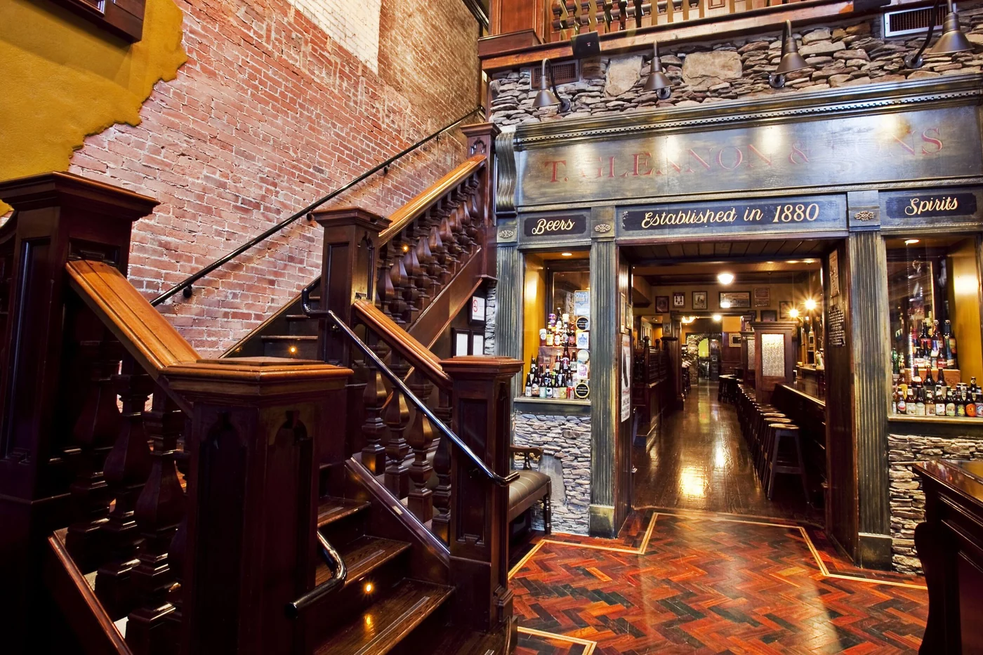 Interior de Rí Rá Irish Pub en Charlotte, con la escalera y el bar en un edificio histórico.