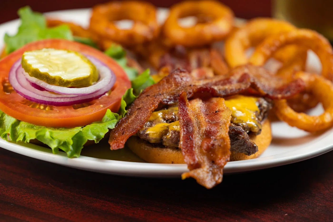 Grilled burger and onion rings at The Trough Bar and Grill. Source: https://thetroughbaraz.com/