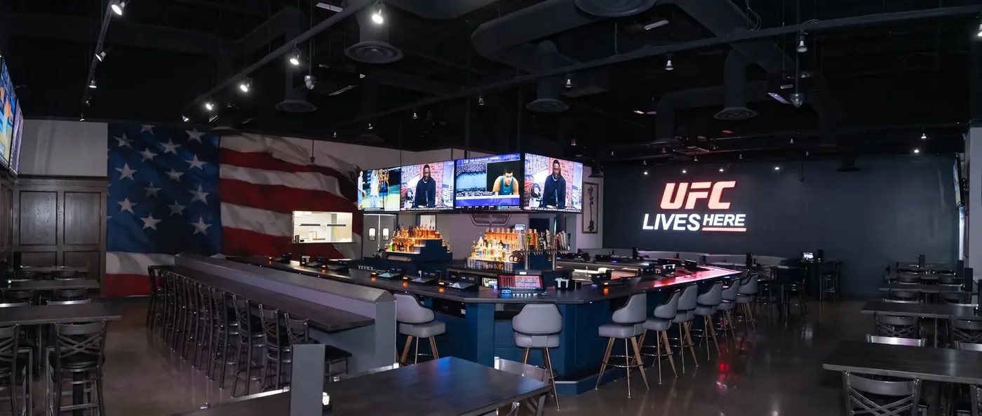 Interior and game-day scene at DJ’s All American Tavern Source: https://www.djstaverns.com/hero-poster-1600.webp