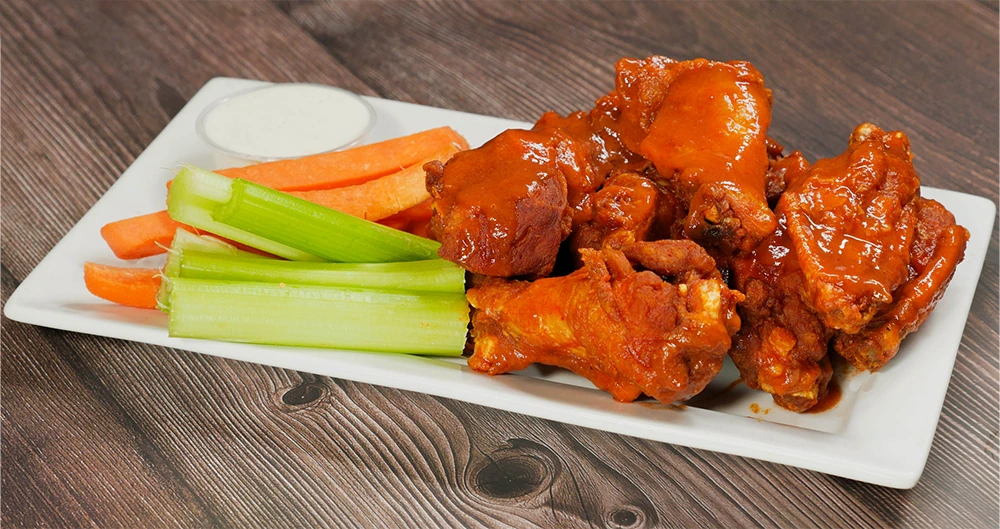 Traditional chicken wings from Just Wing It Source: https://www.justwingitbakersfieldca.com/assets/Traditional-Wings-CE8KIhsG.png