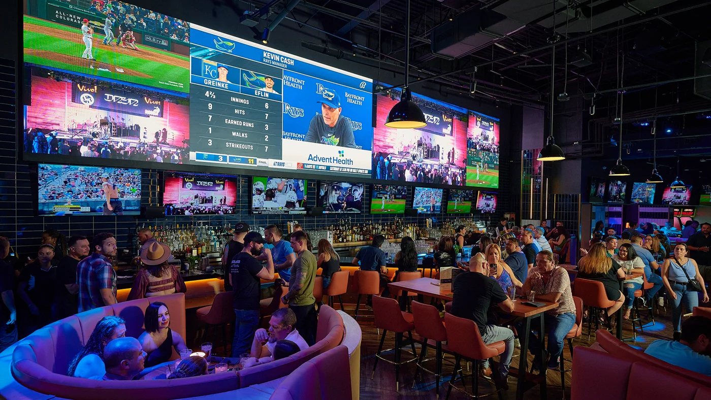 Sports & Social Dolphin Mall interior and viewing screens. Source: https://edge.sitecorecloud.io/cordishc-4m5nplkf/media/District-Websites/Dolphin-Mall/Eat-and-Drink/Sports-and-Social/EatDrinkSportsandSocialHero-1.jpg