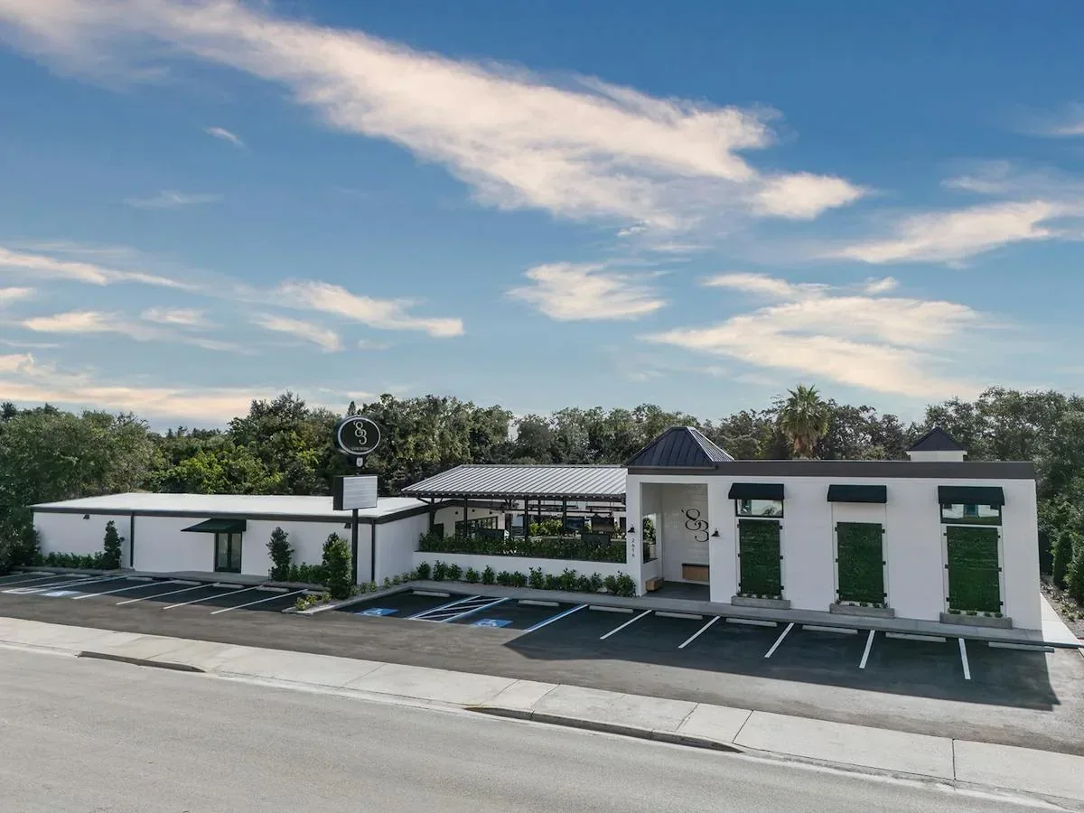 Exterior de 1983 Tampa y espacios de estacionamiento visibles junto al edificio. Source: https://images.getbento.com/accounts/8c4be822ba999096d11ab425e0fe31b8/media/images/66698DJI_20250826093704_0035_D-Edit-2.jpg?w=1200&fit=crop&auto=compress,format&cs=o