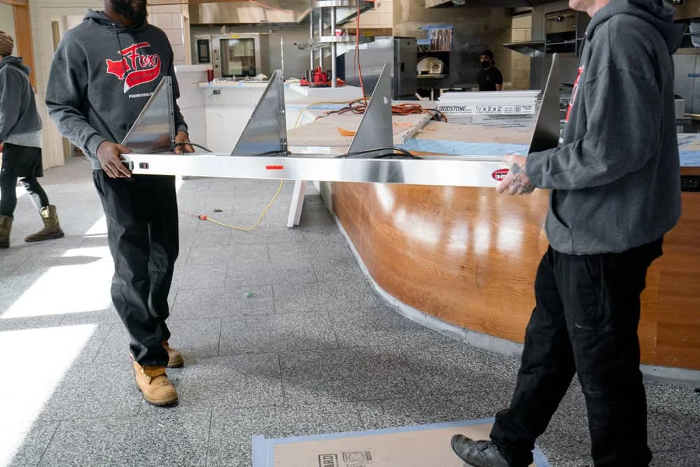 Fox Moving & Storage movers carrying a commercial item, from the official Knoxville page.