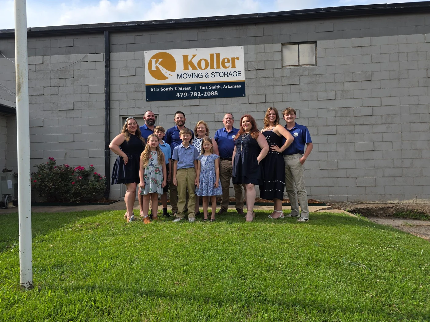 Familia Koller frente al letrero de la empresa en Fort Smith