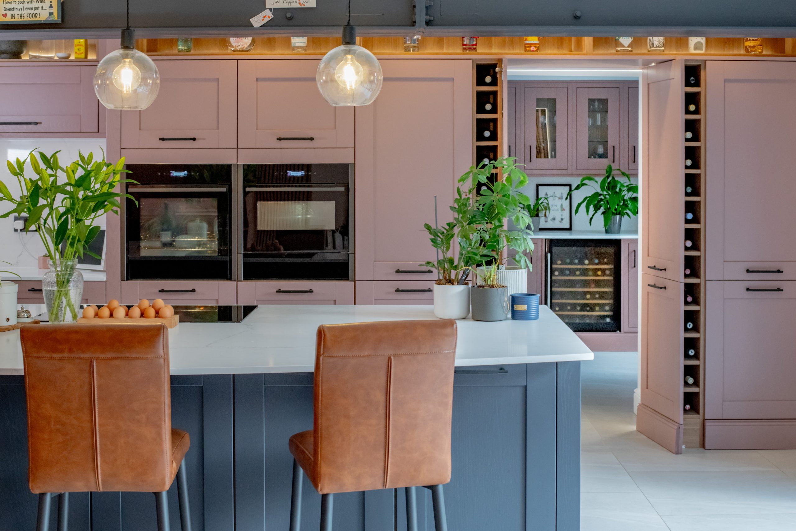 Cocina con muebles en tono malva, isla central y horno empotrado.