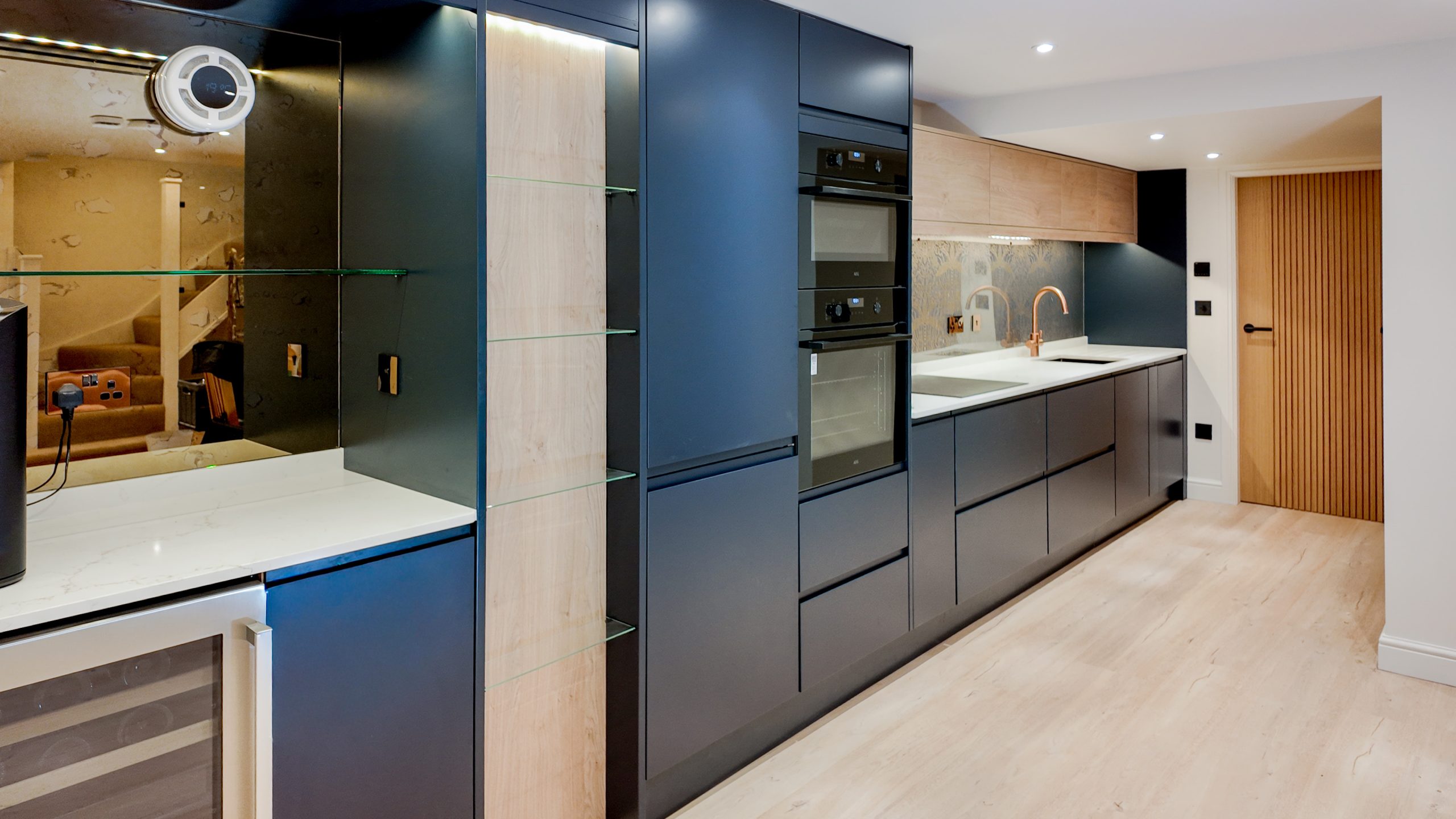 Cocina moderna de muebles oscuros con electrodomésticos empotrados.