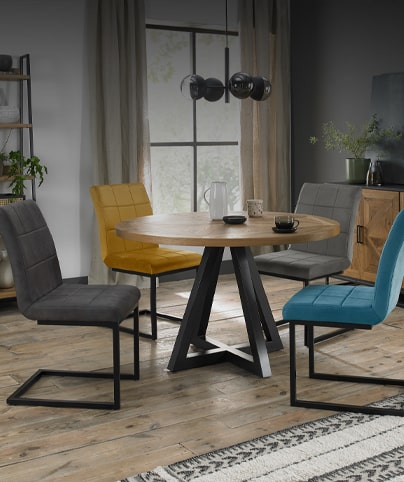 Comedor con mesa de madera, sillas tapizadas y lámparas colgantes.