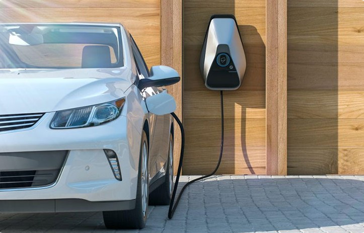 Punto de carga para un vehículo eléctrico junto a un automóvil.