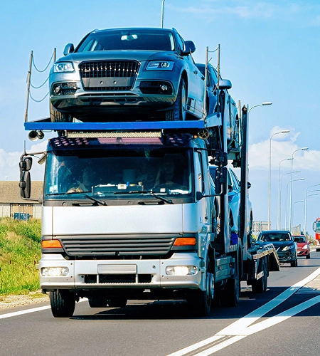 Camión portavehículos con varios automóviles durante un traslado.