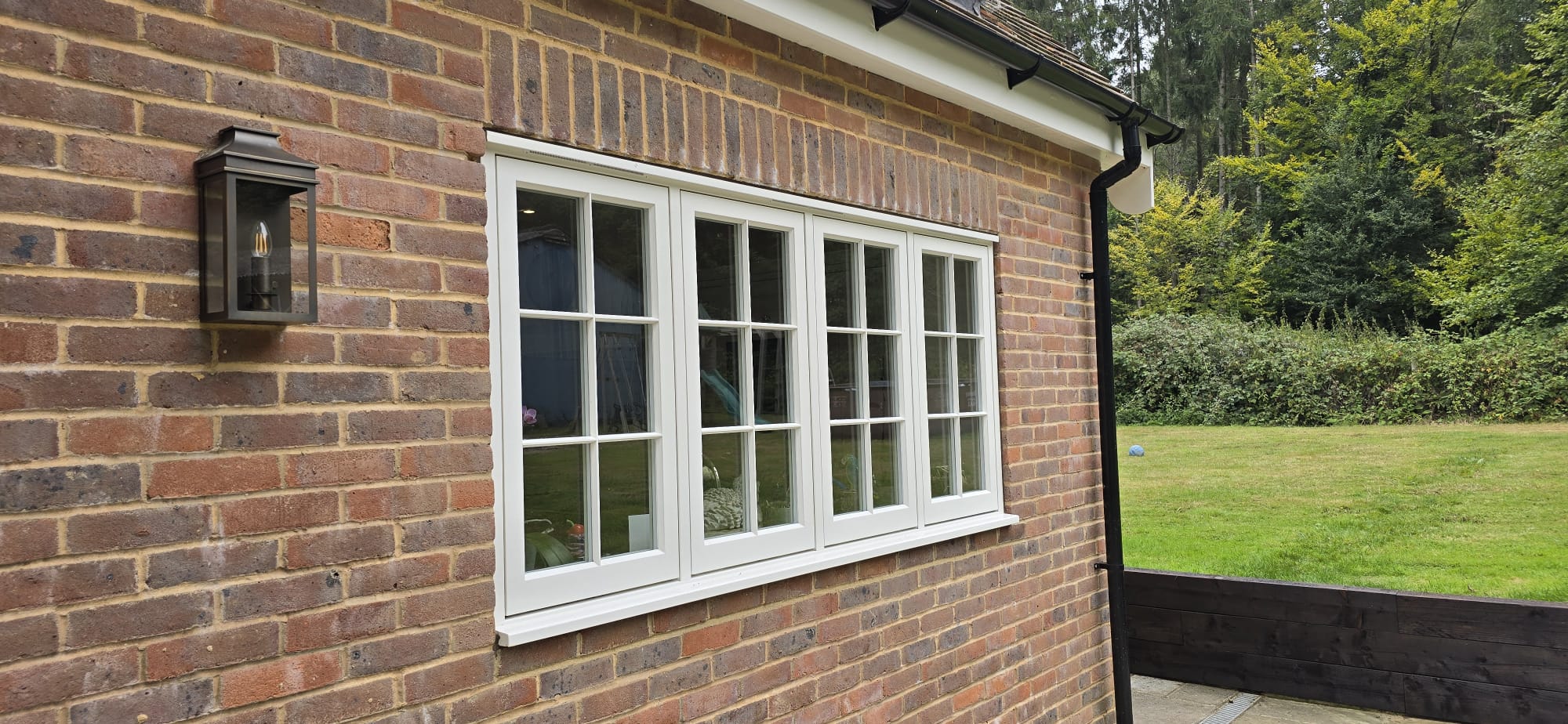 Ventana de madera blanca instalada en una casa de ladrillo / White timber window installed in a brick house.