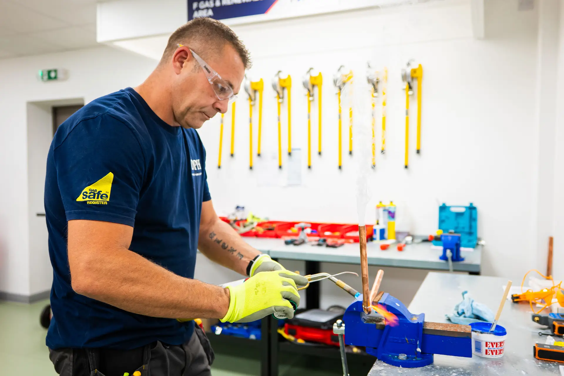 Instructor working with heating and plumbing equipment in a training room / Instructor trabajando con equipos de calefacción y fontanería en una sala de formación