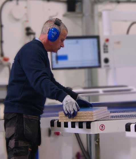 Operador trabaja con un panel en el taller de CNC Creations / Operator working with a panel at the CNC Creations workshop