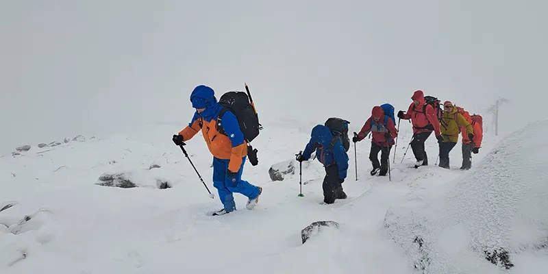 Grupo de montañistas avanzando por una ruta nevada / Group of mountaineers hiking a snowy route