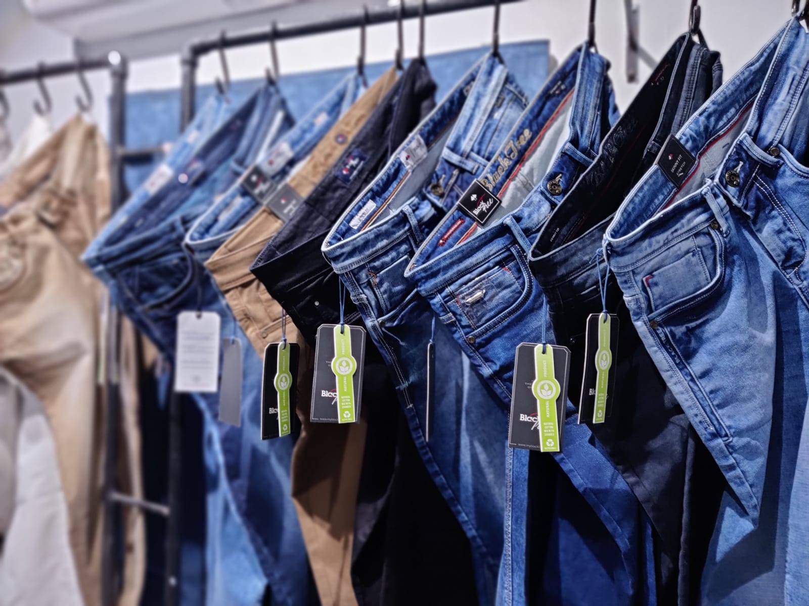 Vaqueros de mezclilla de BlackTree colgados en un perchero / BlackTree jeans hanging on a clothing rack