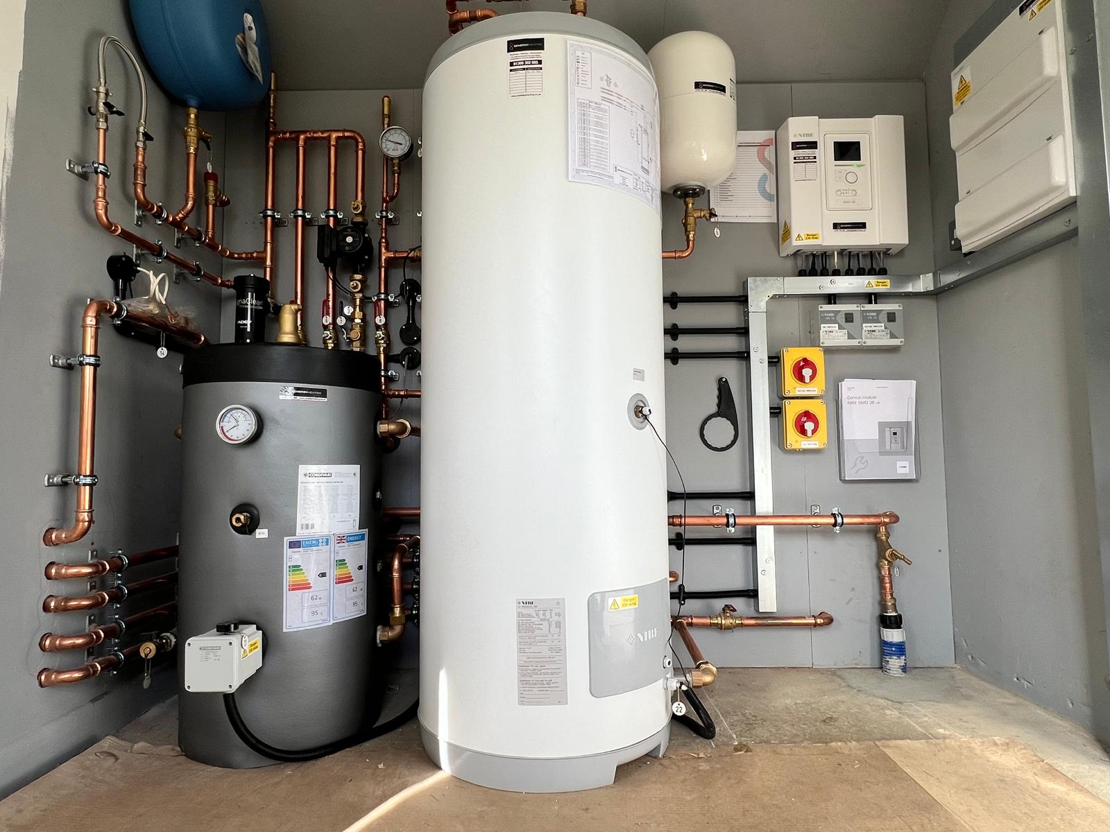 Depósito de agua y equipo de bomba de calor instalados en una sala técnica