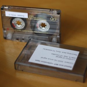 Audiocasete junto a una cinta de prueba para calibrar reproductores de casete.