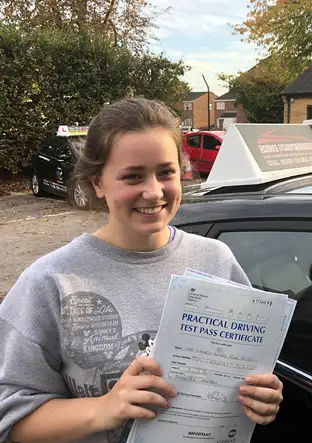 Alumna sostiene su certificado tras aprobar el examen de conducir / A student holding her certificate after passing a driving test