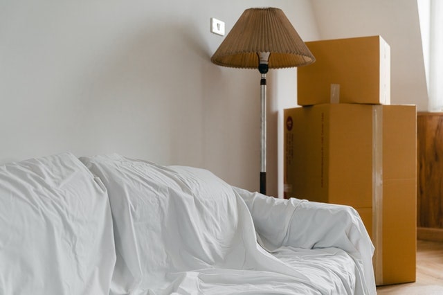 Habitación con mobiliario cubierto y cajas preparada para un vaciado / Room with covered furniture and boxes prepared for a clearance