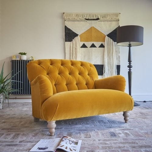 Yellow upholstered armchair displayed in a living room setting.