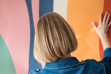 A customer applying a wall design in a home interior.