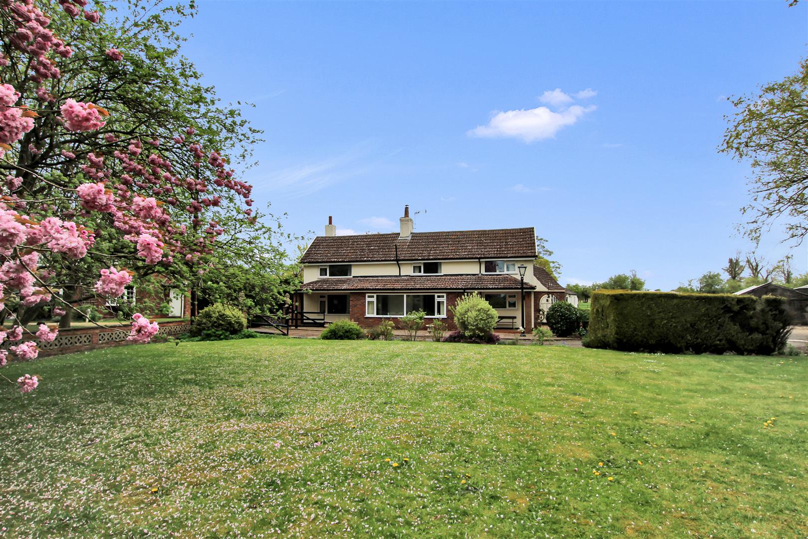 Country home viewed across a landscaped garden.