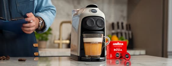 Lavazza capsule coffee machine being used to prepare a drink.