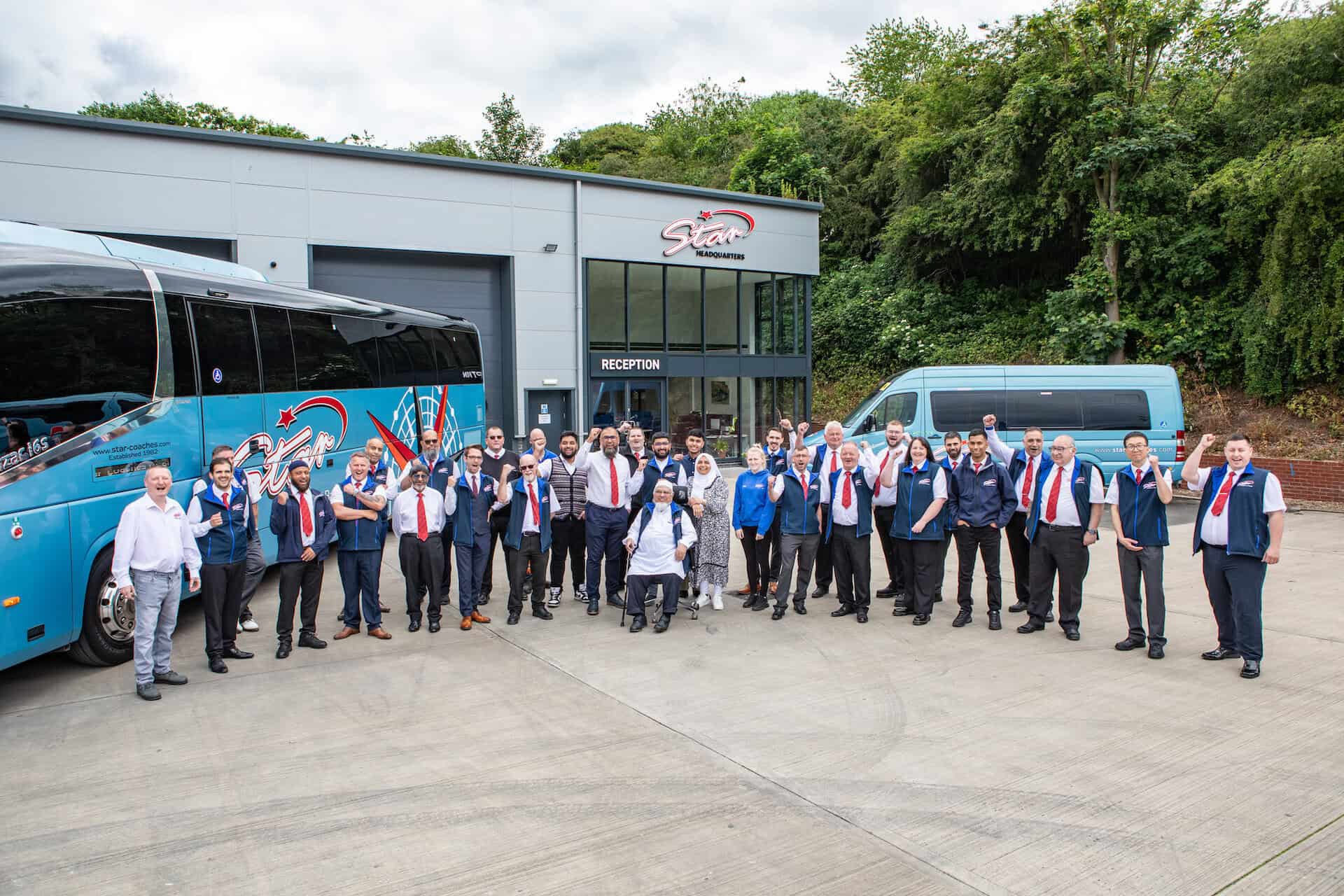 Star Coaches staff standing beside branded coaches at the depot.