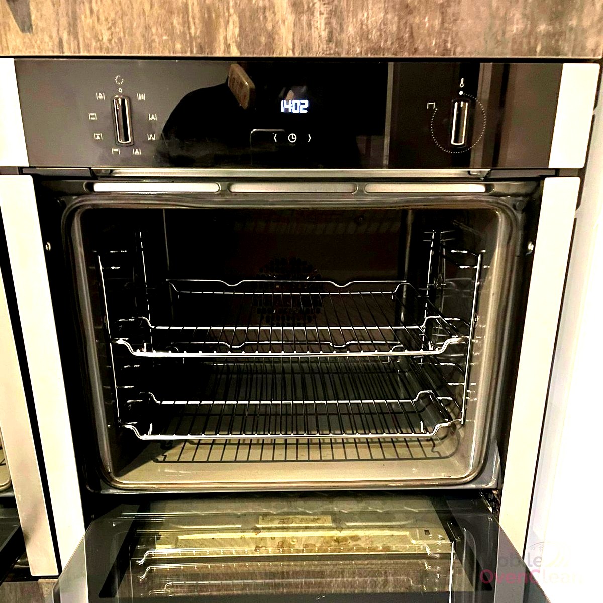 Open oven with racks and a clean interior after a professional service.