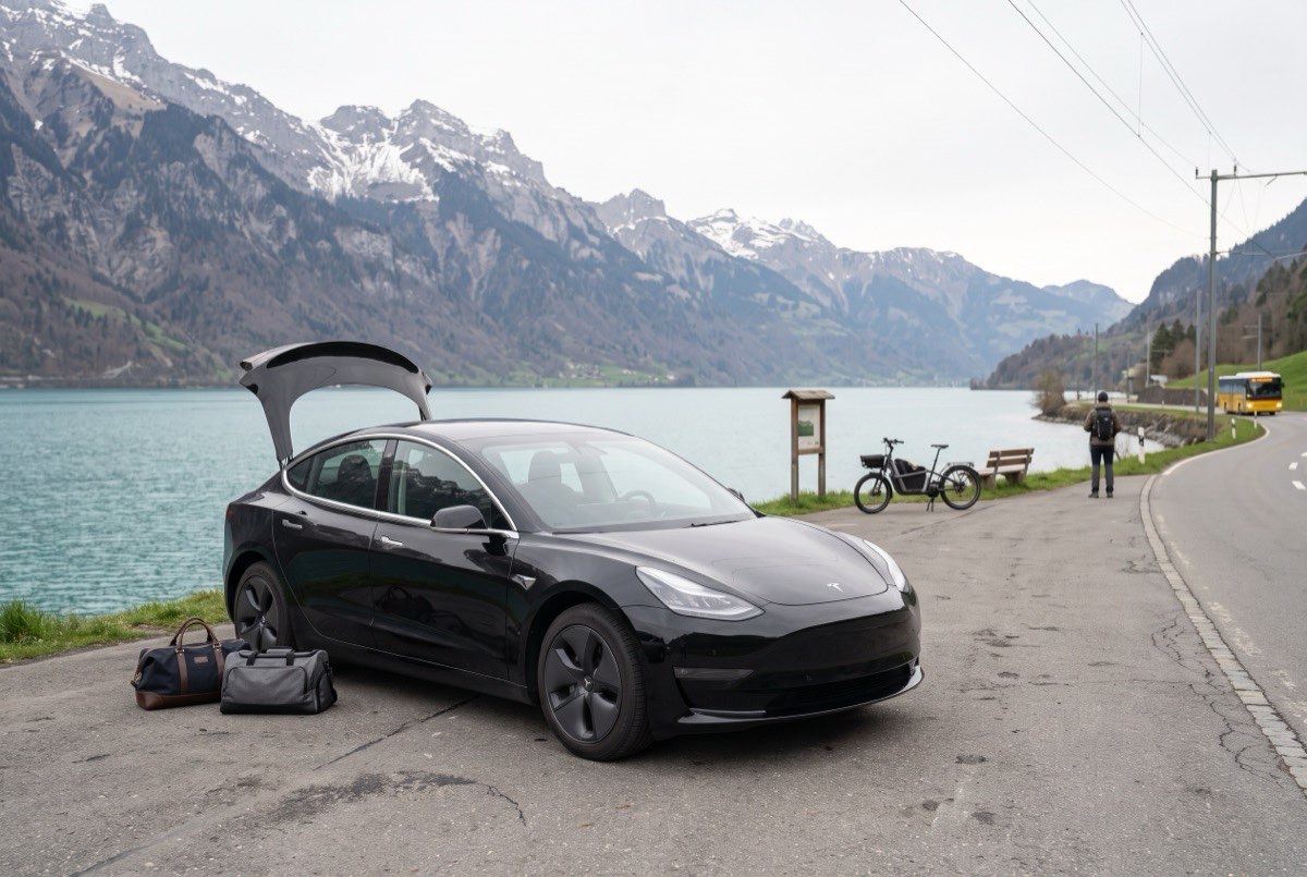 DRAIV rental car parked beside a Swiss lake