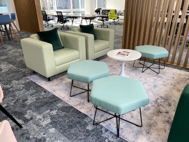 Refurbished lounge chairs and tables displayed in an office furniture showroom
