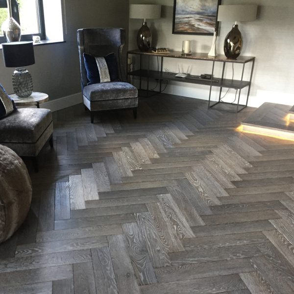 Finished herringbone wood flooring in a furnished room