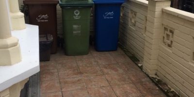 Household recycling bins arranged outside a property
