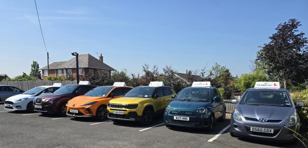 Driving school cars parked together, including a vehicle with learner plates