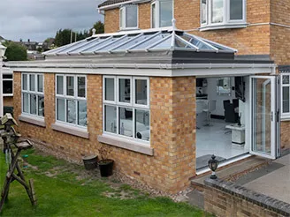 Brick home extension with a glazed roof and white-framed windows